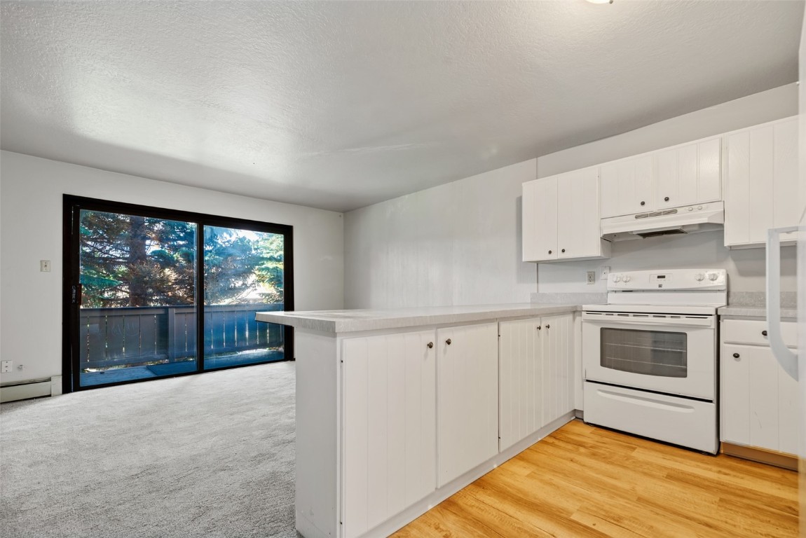 a kitchen with white cabinets and white appliances