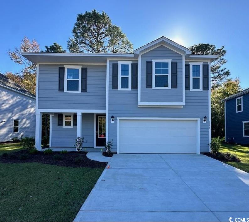 View of property featuring a front yard and a gara