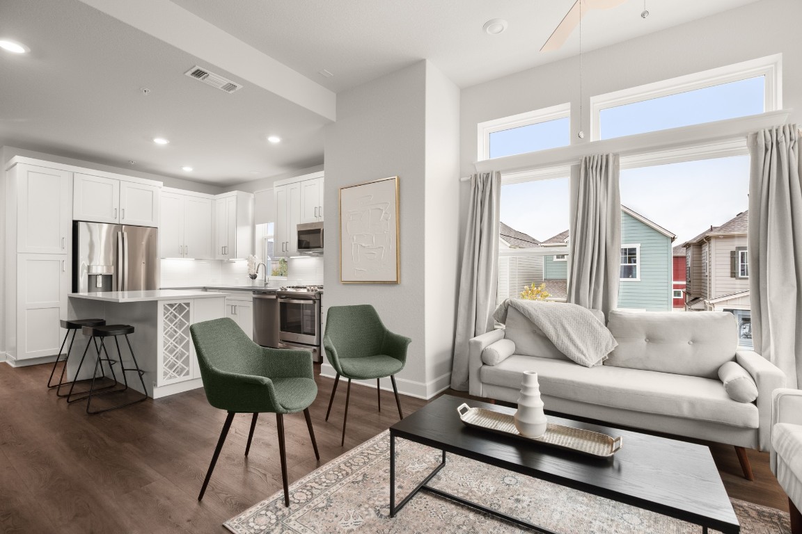 a living room with furniture and a dining table with wooden floor