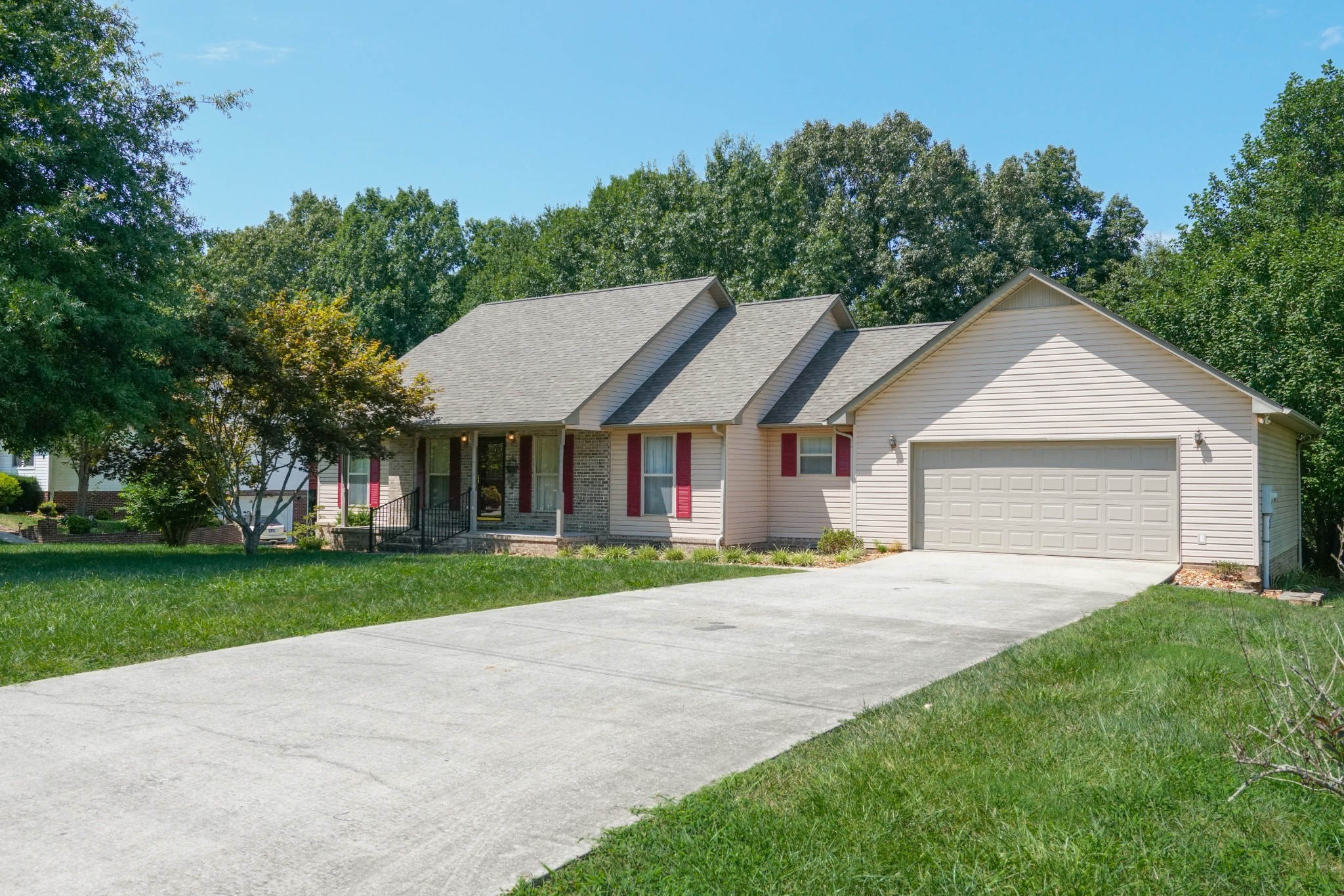 a front view of a house with a yard and trees