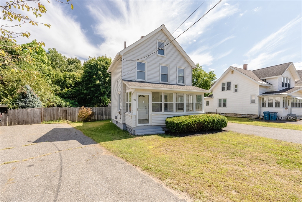 a front view of a house with a yard and potted plants