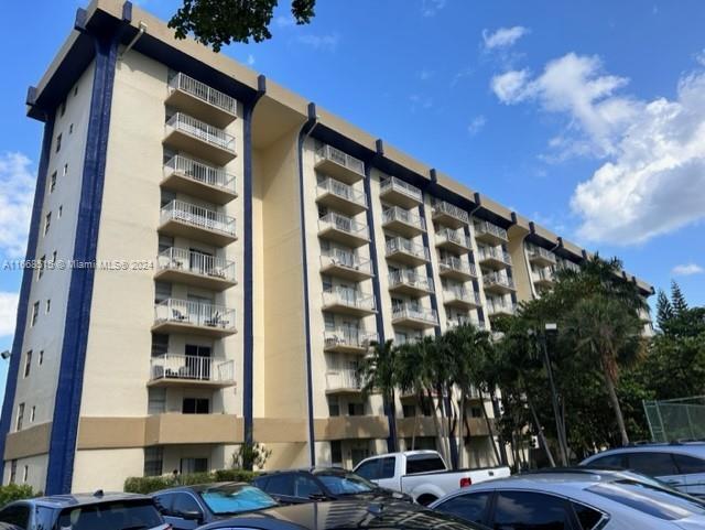 a front view of a building with street view and trees