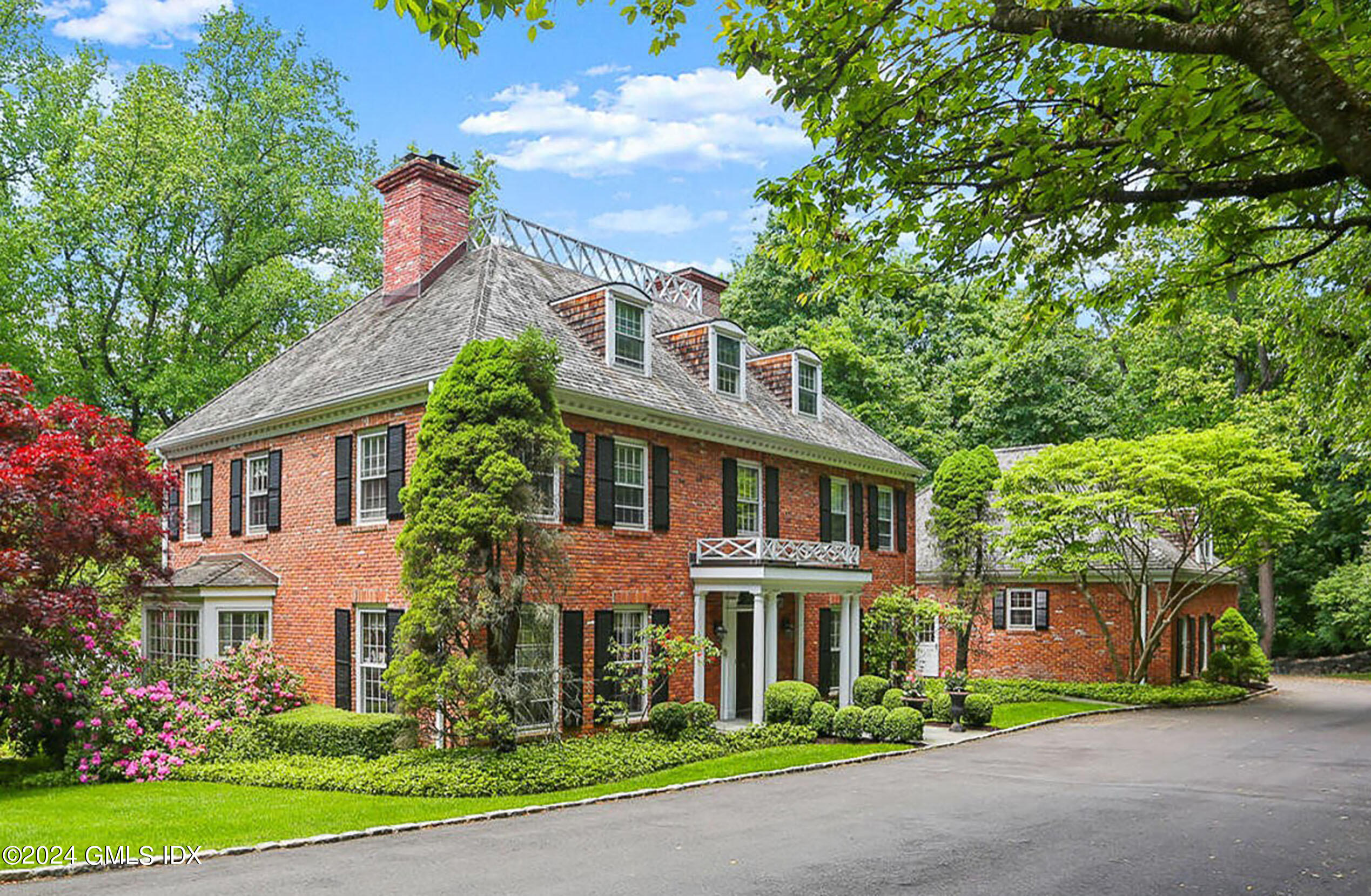 a front view of a house with a yard and trees