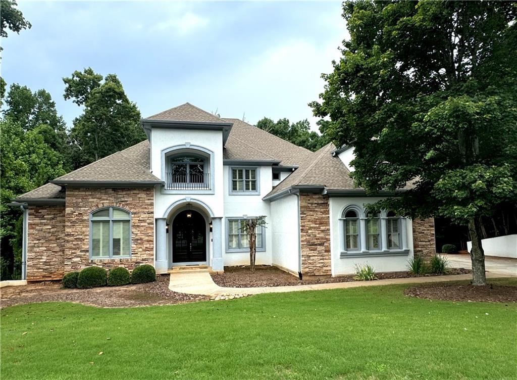 a front view of a house with a garden and yard