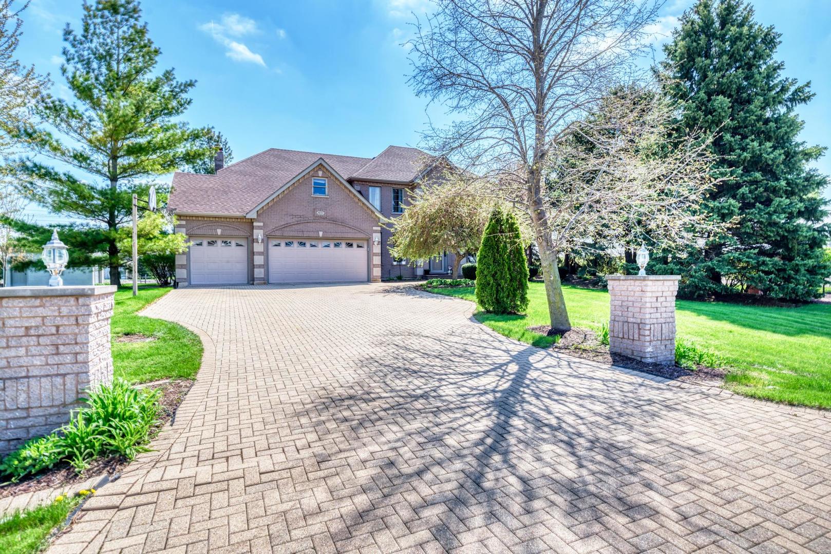 a front view of a house with a yard and trees