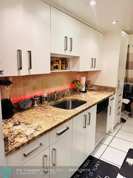 a kitchen with a sink a stove and cabinets