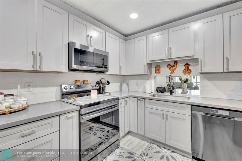 a kitchen with white cabinets and appliances