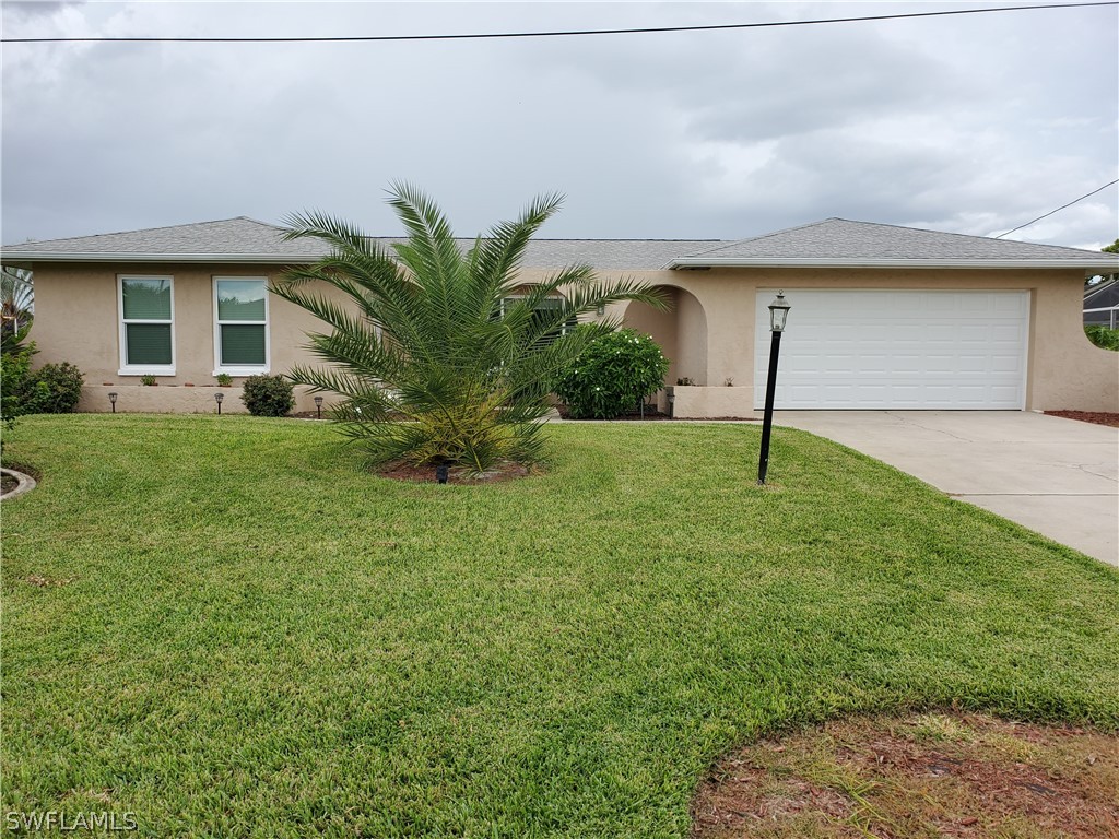 a front view of house with a garden