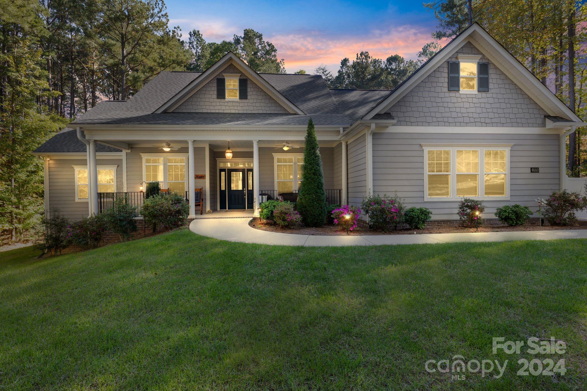 a front view of a house with a yard and potted plants