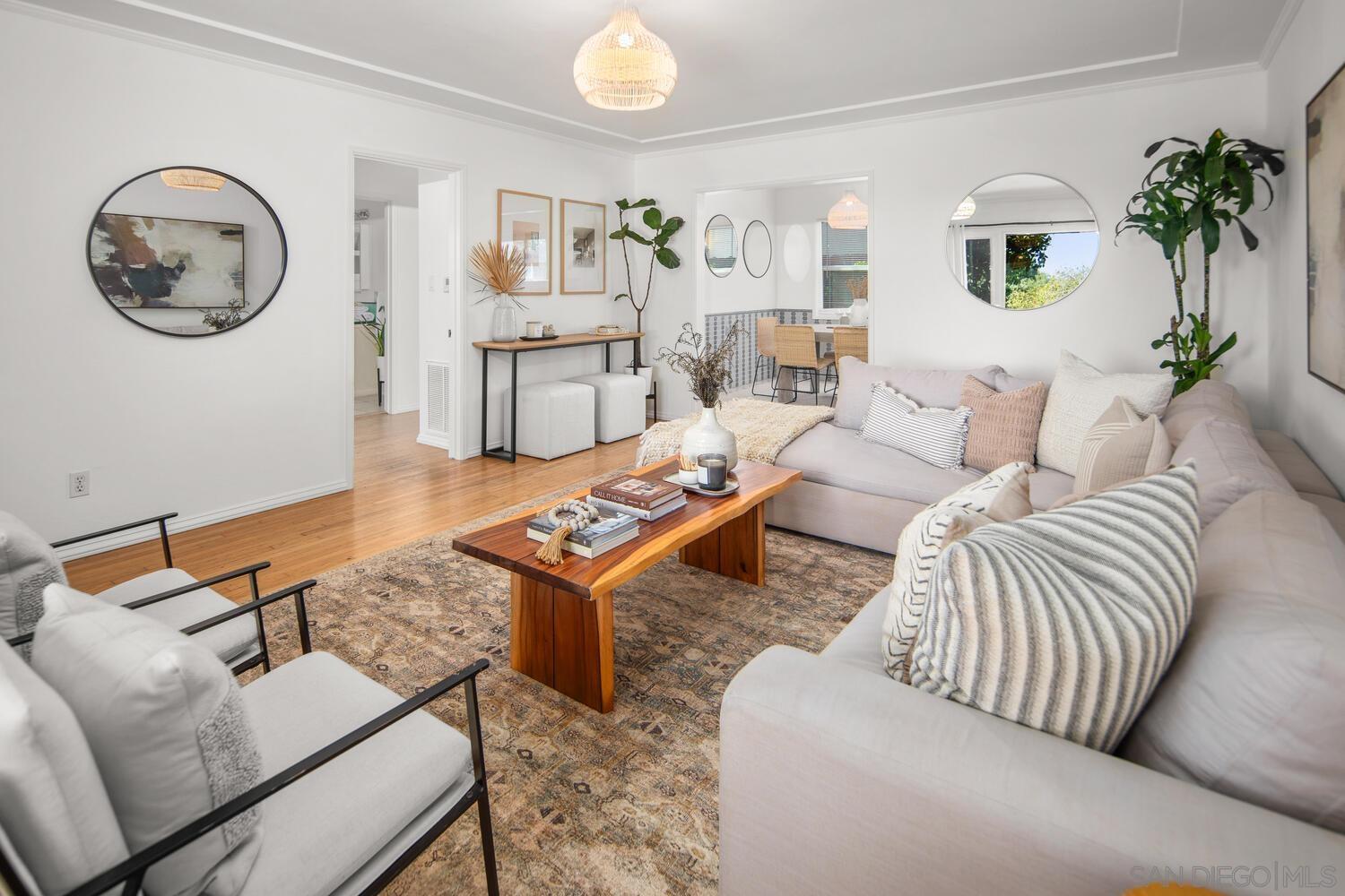 a living room with furniture a table and a potted plant