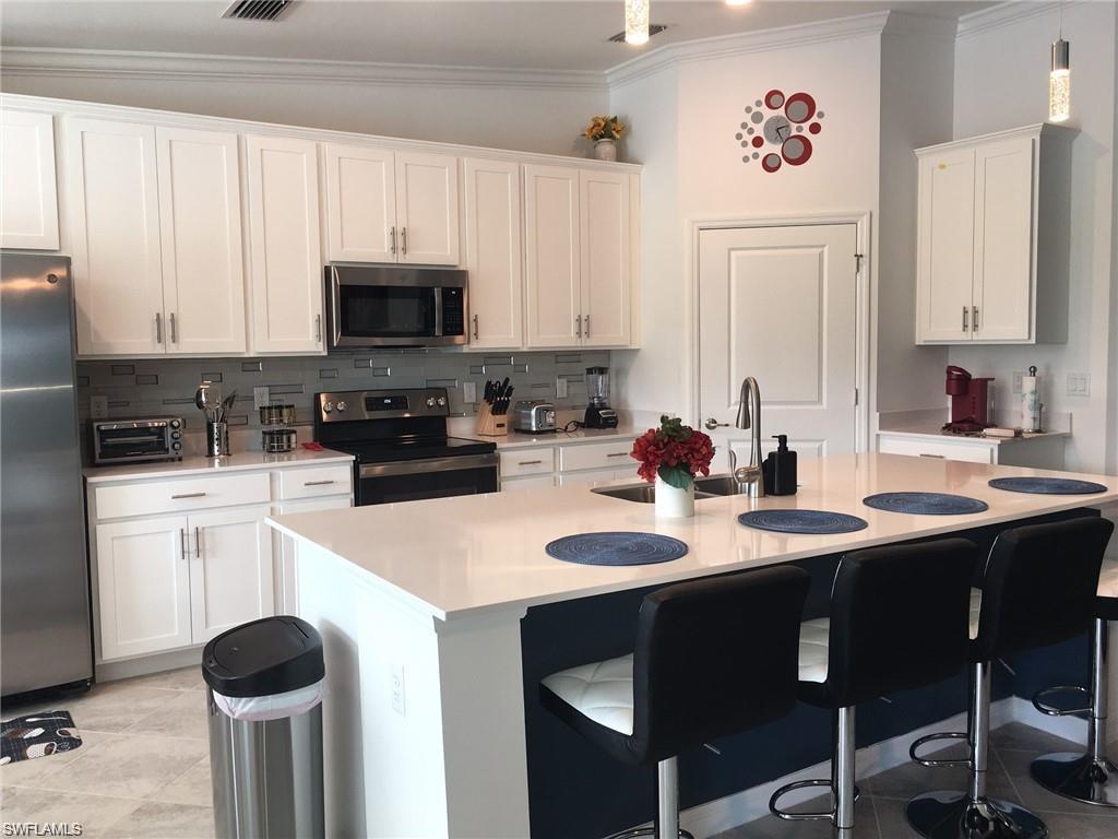 a kitchen with granite countertop a sink stove and white cabinets