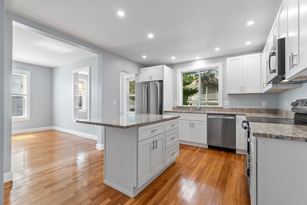 a kitchen with granite countertop wooden floors and white appliances