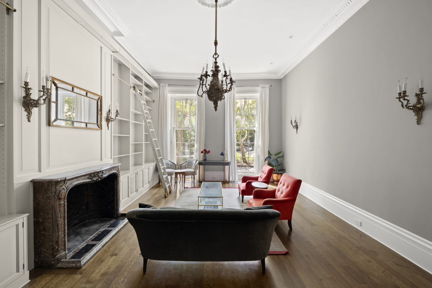 a dining room with wooden floor a chandelier a glass table and chairs