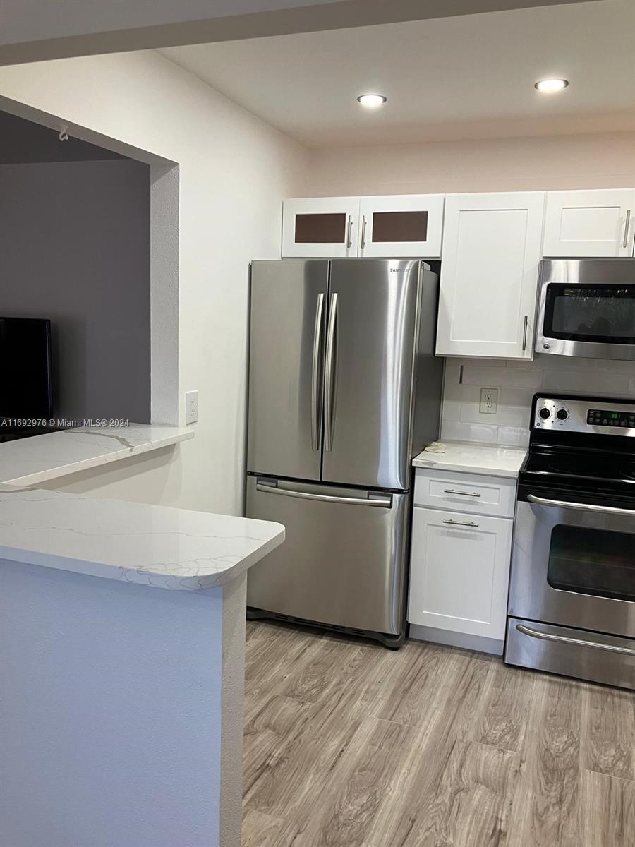 a kitchen with a refrigerator sink and stove top oven