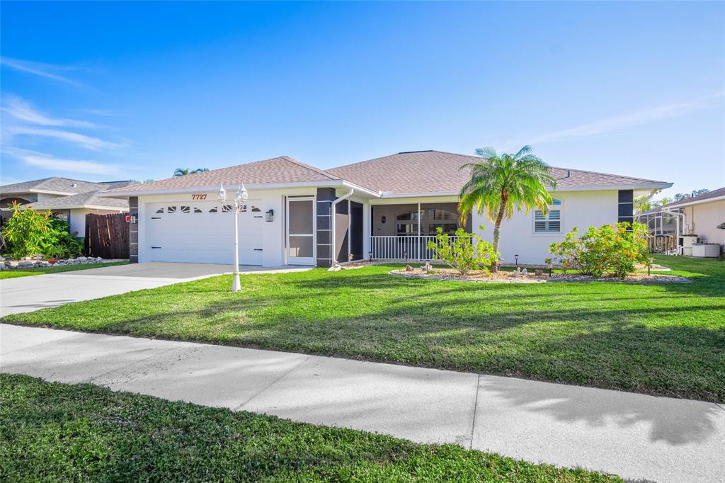 a front view of a house with a yard and palm trees