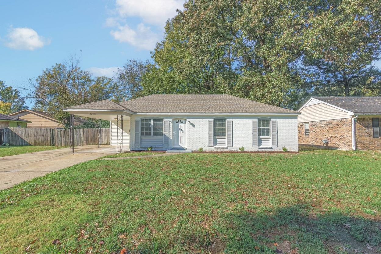 Ranch-style house with a carport and a front lawn