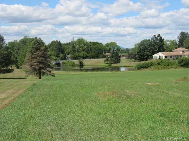 a view of a green field with wooden fence