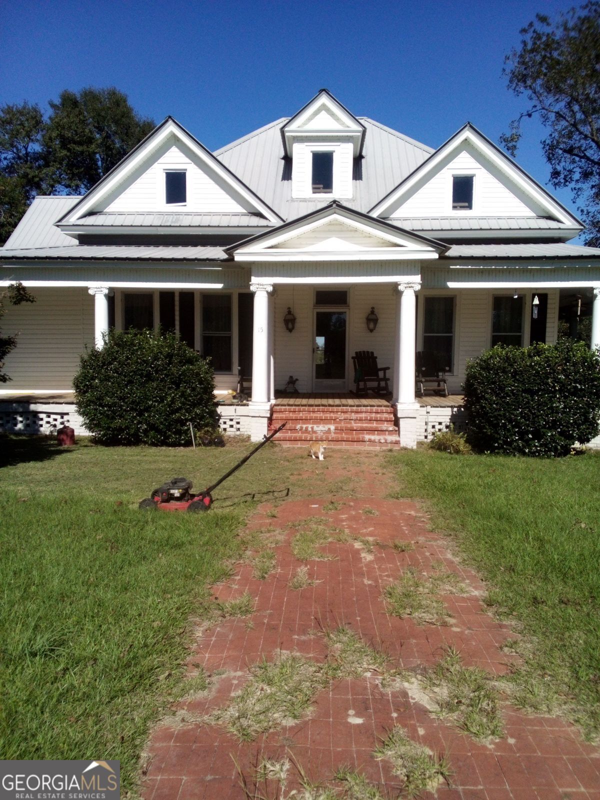 a front view of a house with a yard and potted plants