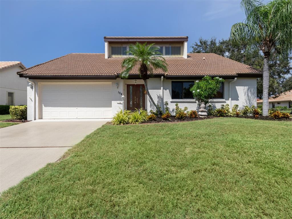 a front view of a house with a garden and plants