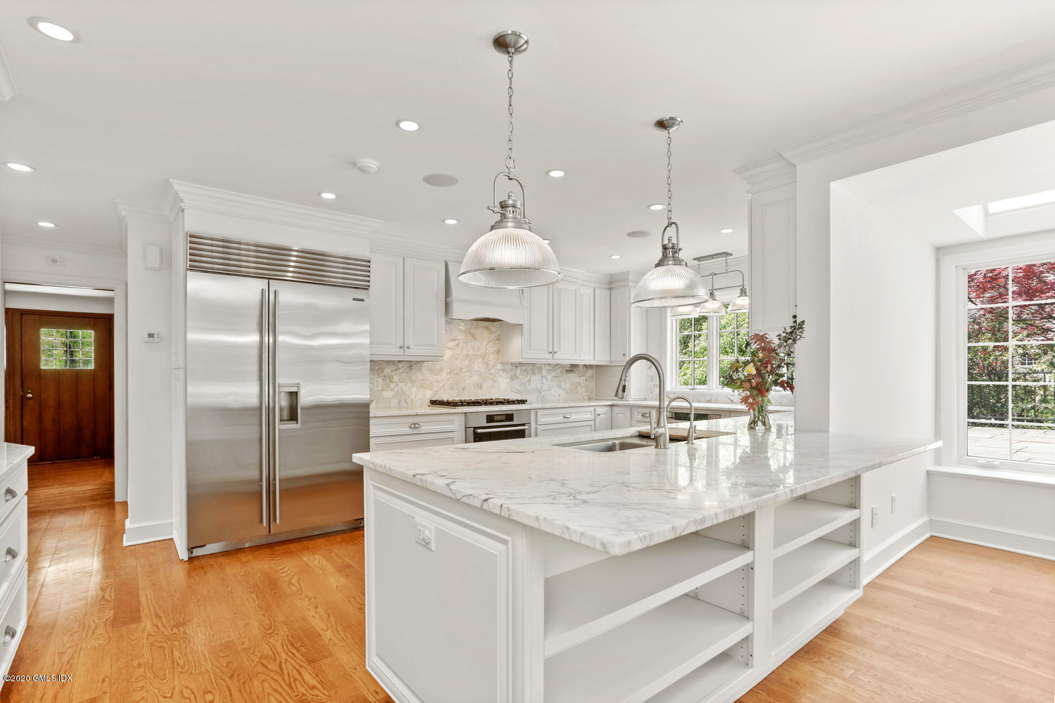 a large kitchen with granite countertop a large kitchen island a sink stainless steel appliances and cabinets