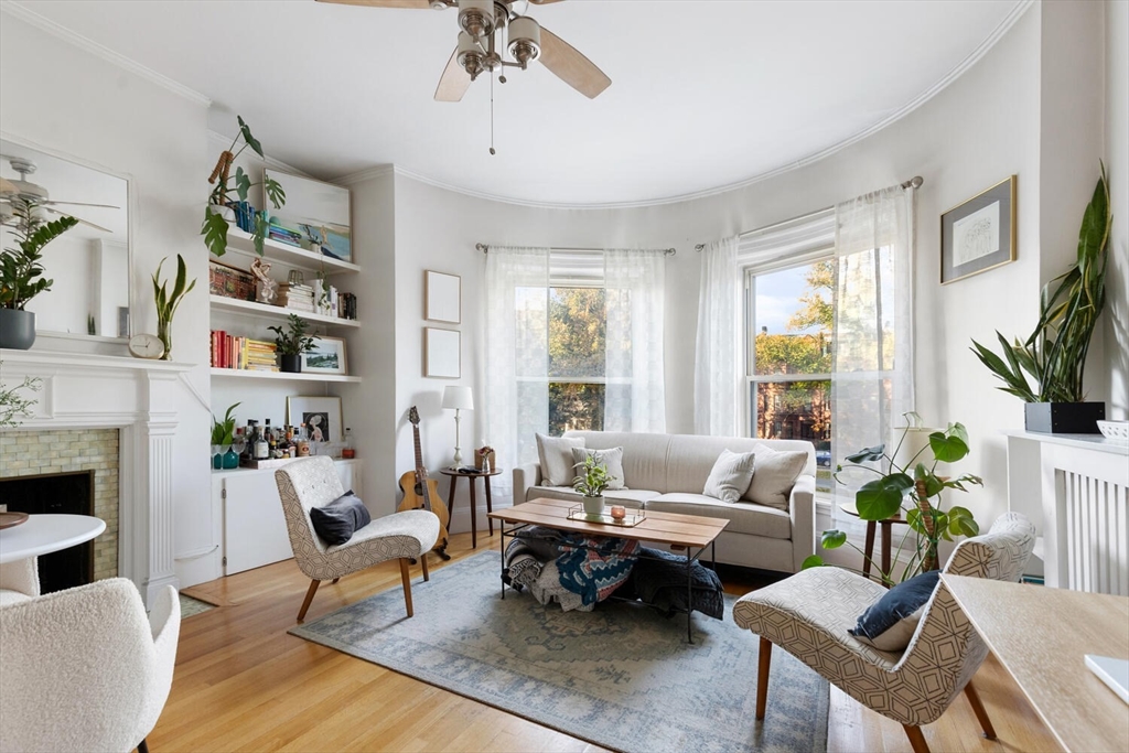 a living room with furniture fireplace and a large window