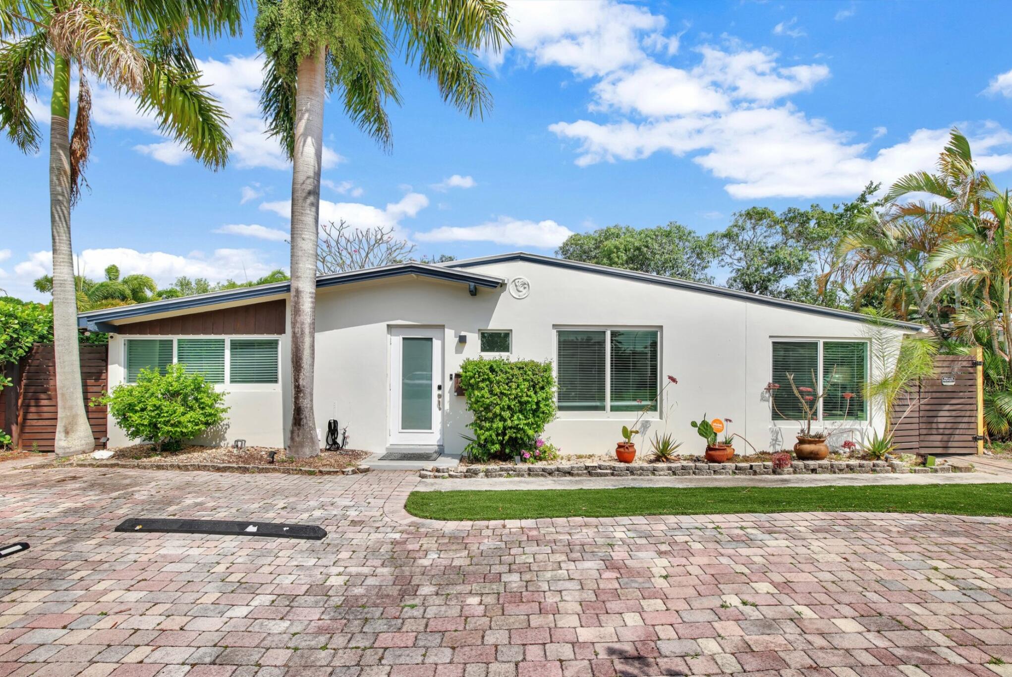 a front view of a house with garden space and patio