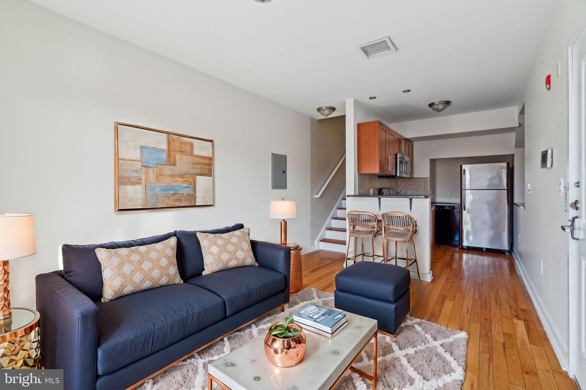 a living room with furniture and a wooden floor