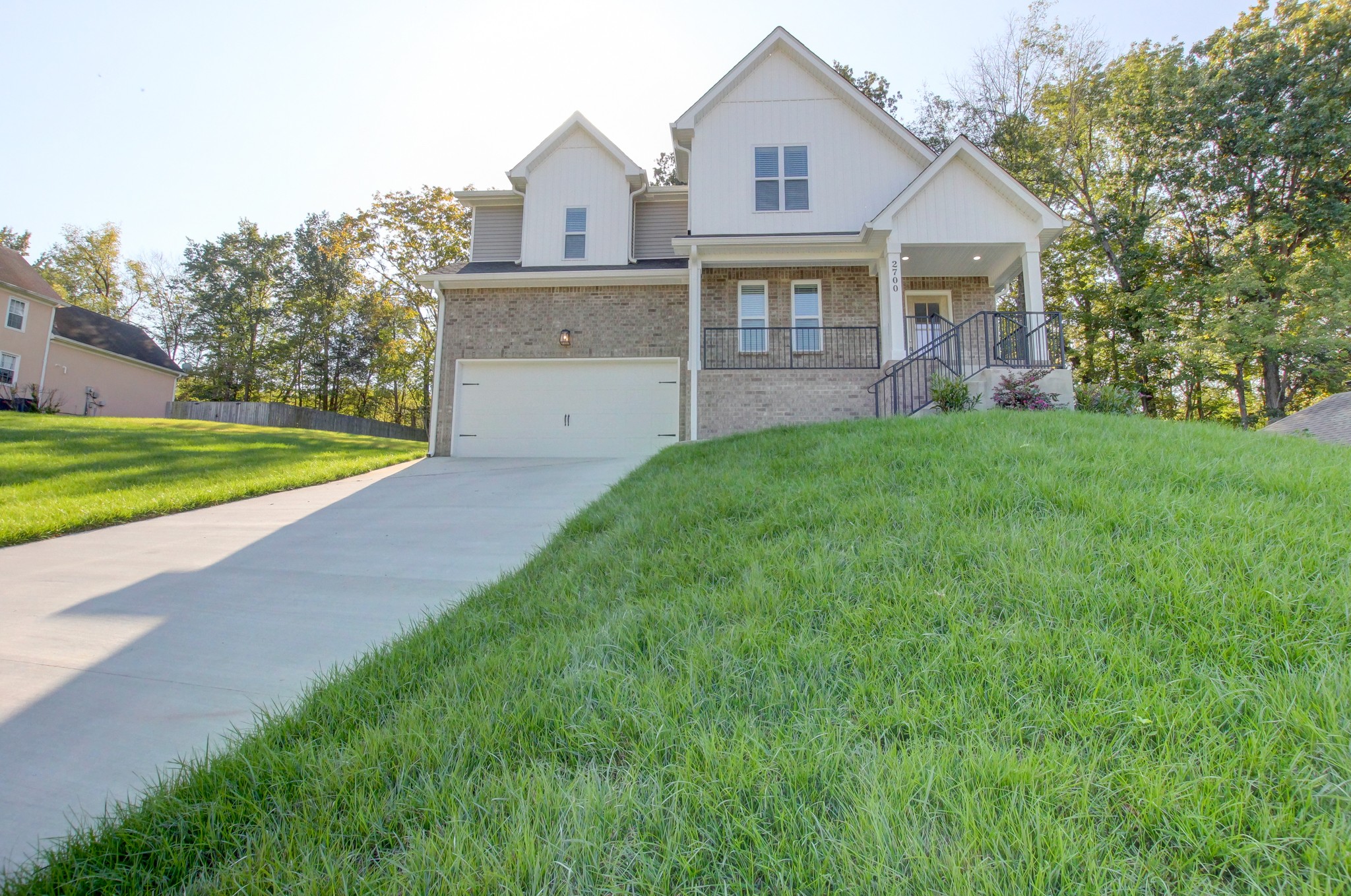 a front view of a house with a yard and trees