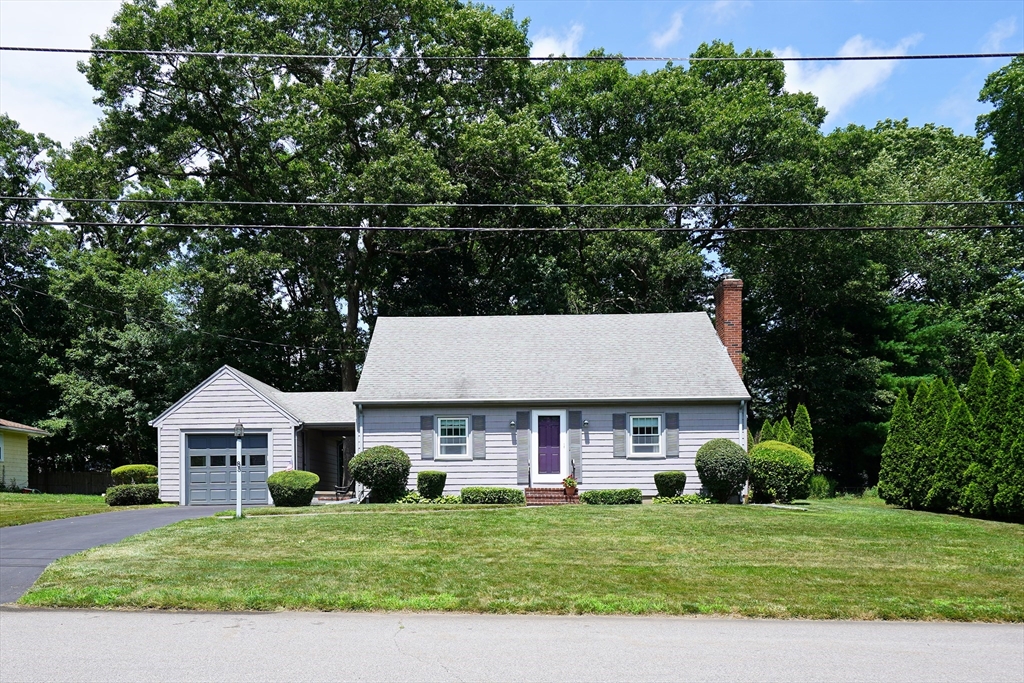 a view of a white house with a big yard and large trees