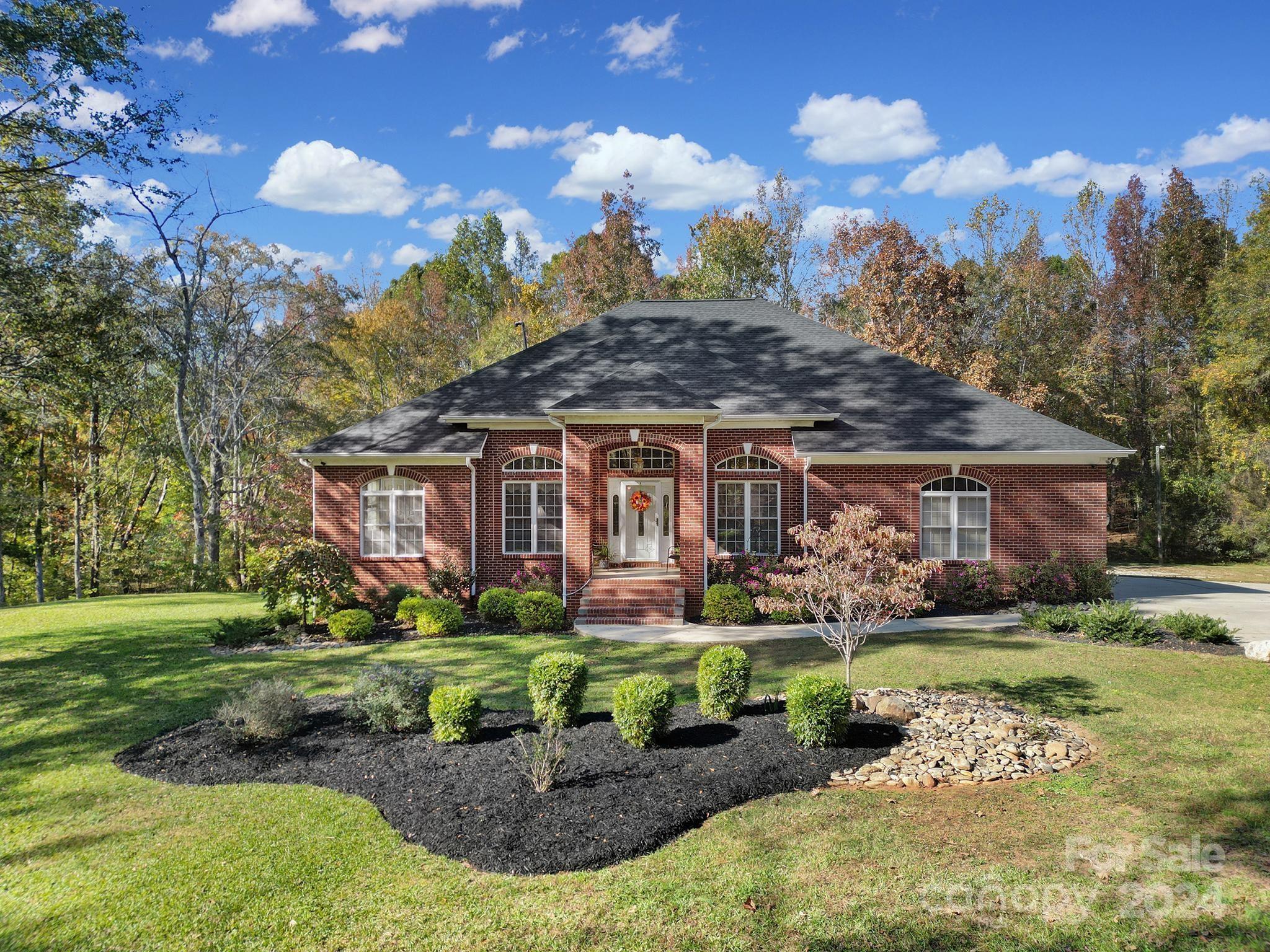 a aerial view of a house with a yard and a large tree