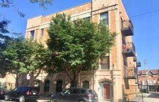 a front view of a building with trees