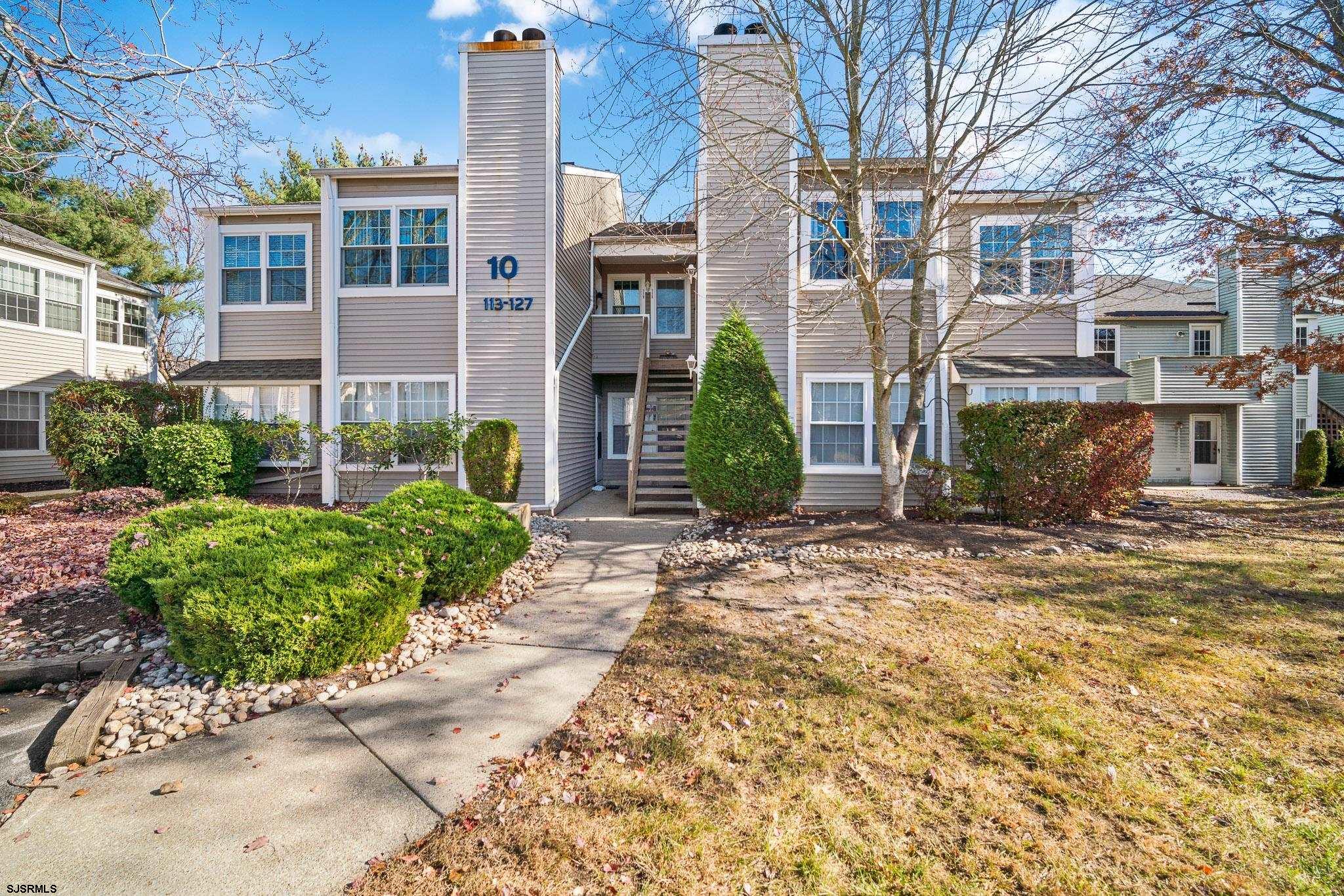 front view of a brick house with a yard