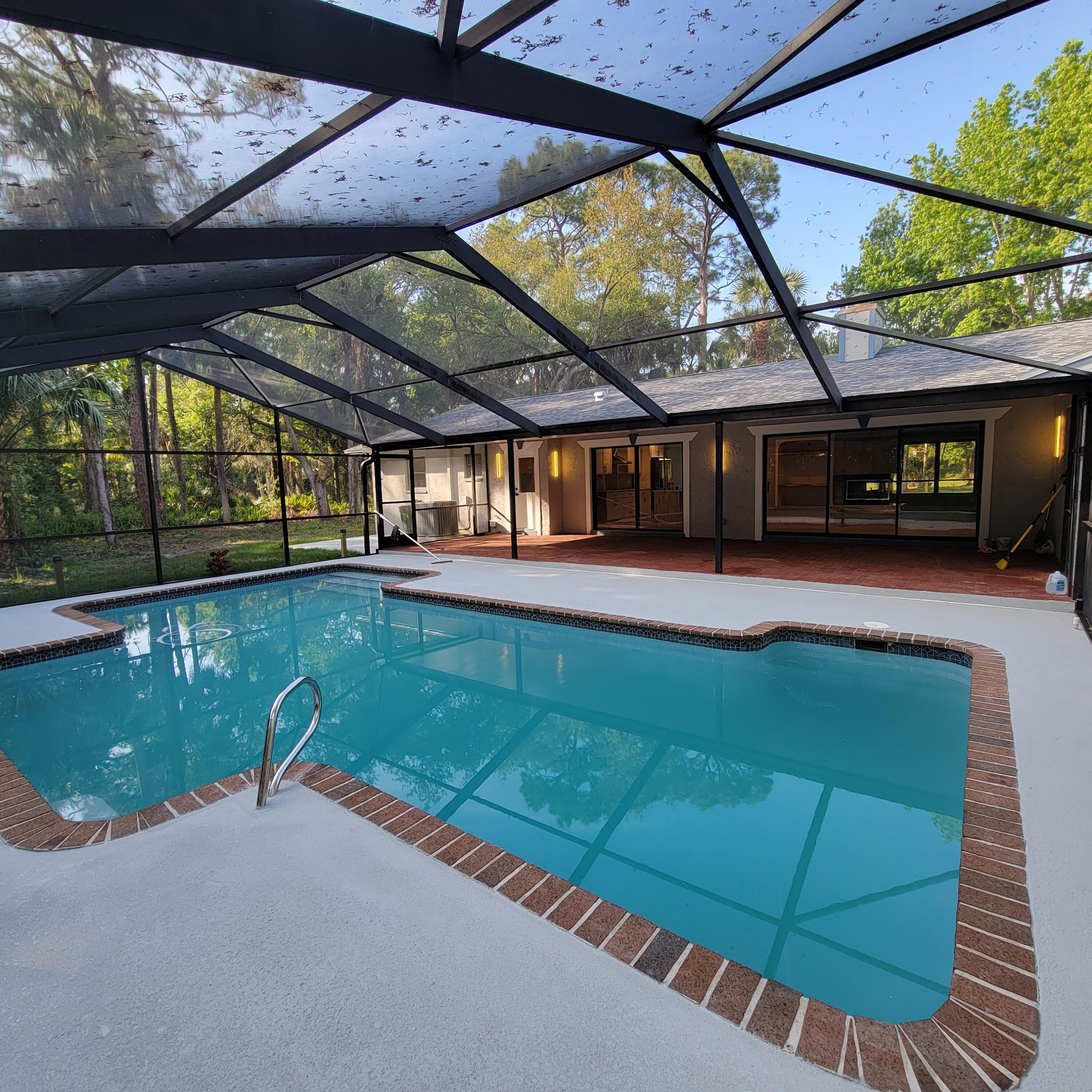 a view of a swimming pool with a patio and a yard