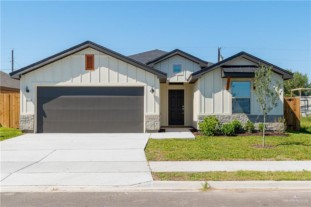 View of front of home with a front lawn and a garage