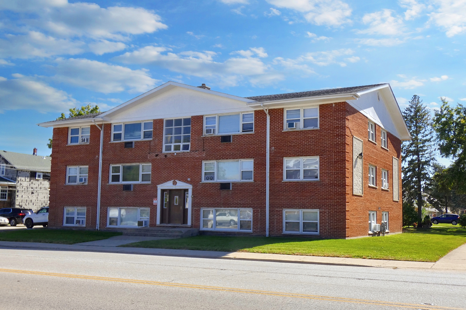 a view of a brick building next to a yard