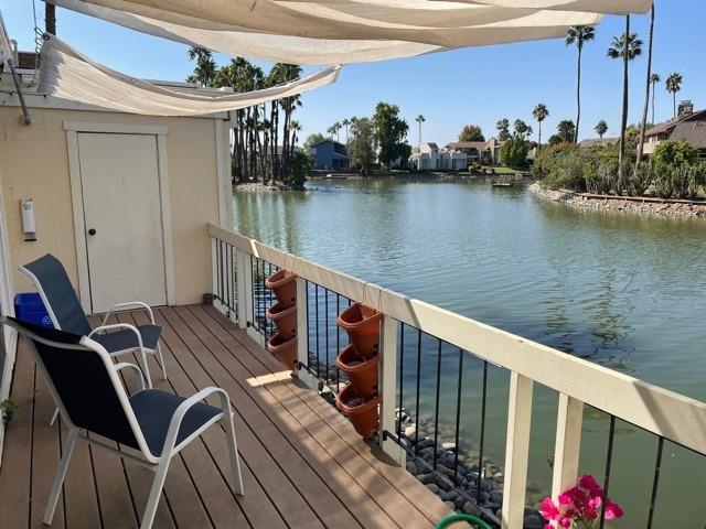 a balcony with wooden floor table and chairs