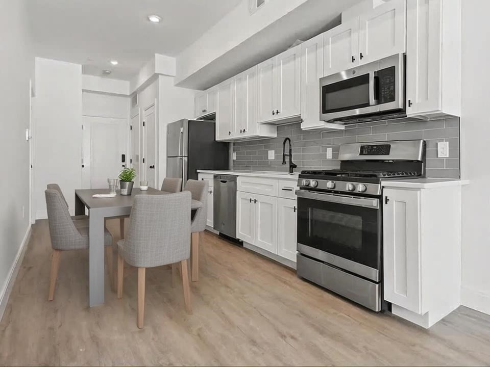 a kitchen with microwave a stove a sink and chairs