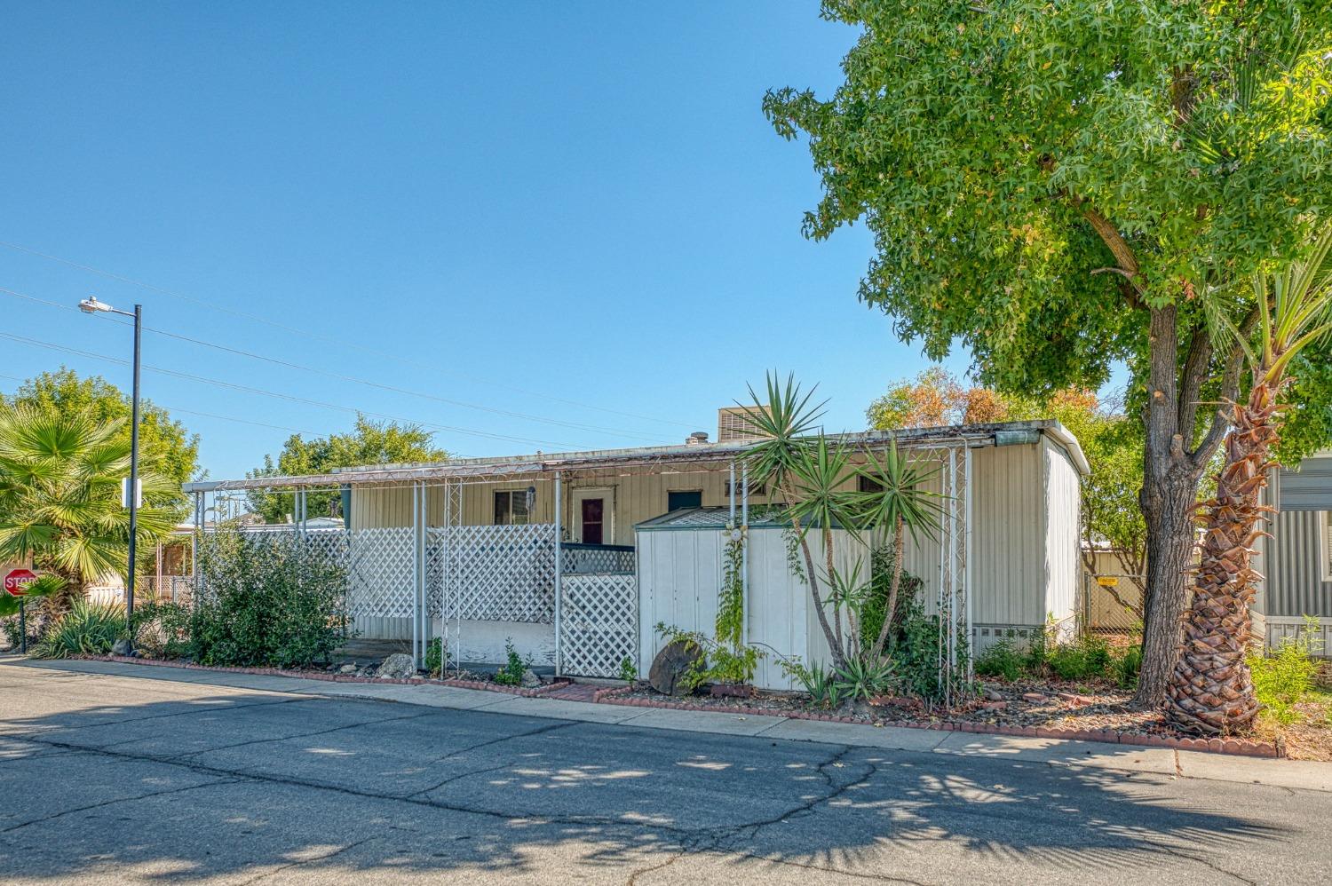 a front view of a house with a yard and potted plants