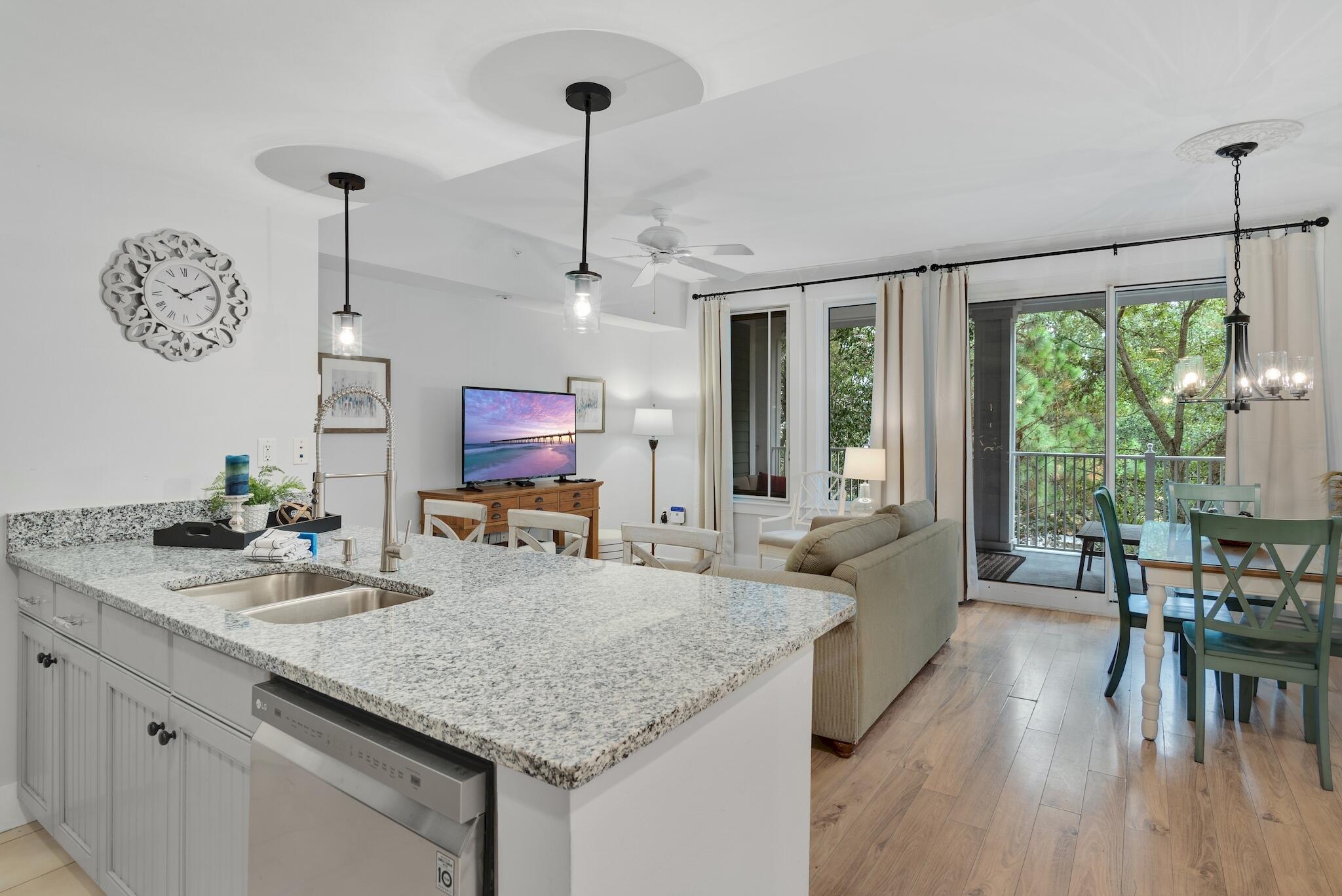 a kitchen with kitchen island granite countertop a table chairs a sink and a chandelier