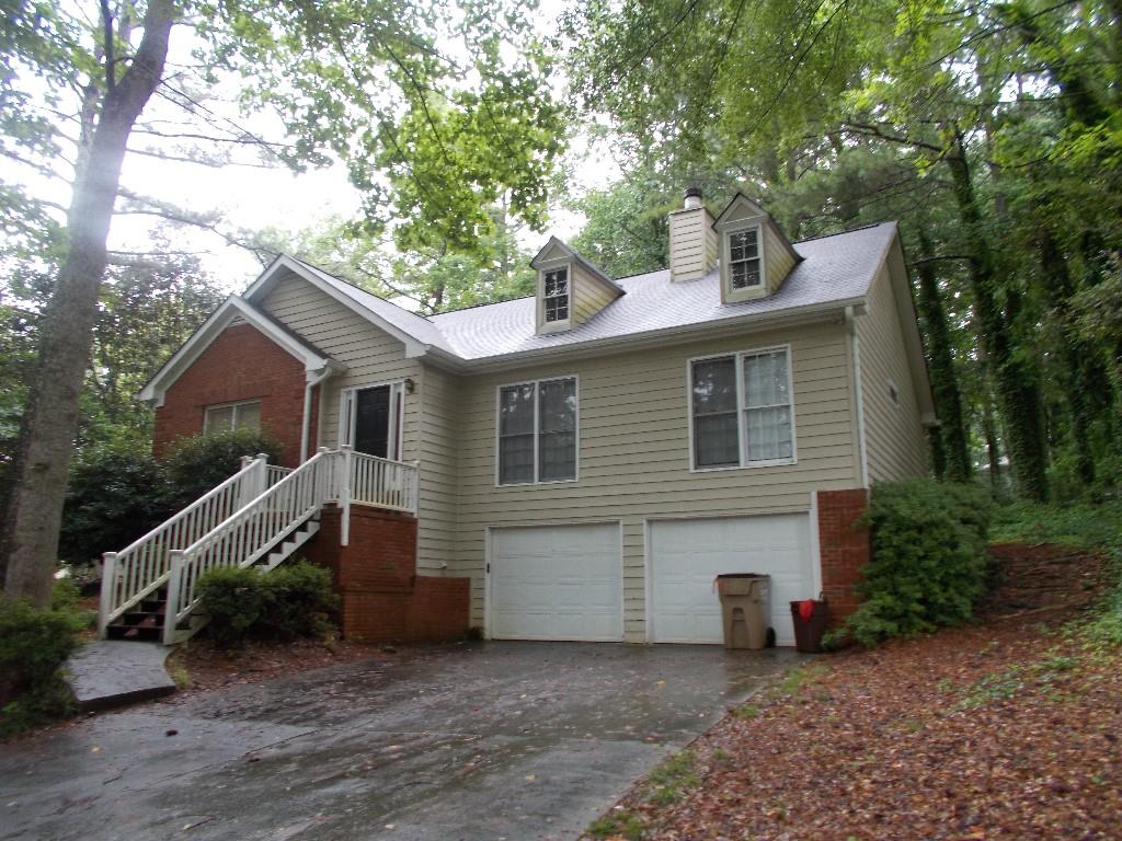 a view of a house with a yard and large tree