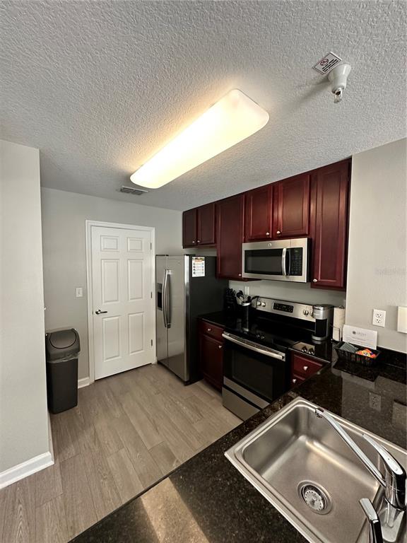 a kitchen with stainless steel appliances granite countertop a refrigerator and a sink