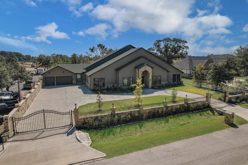 a front view of a house with a garden and lake view