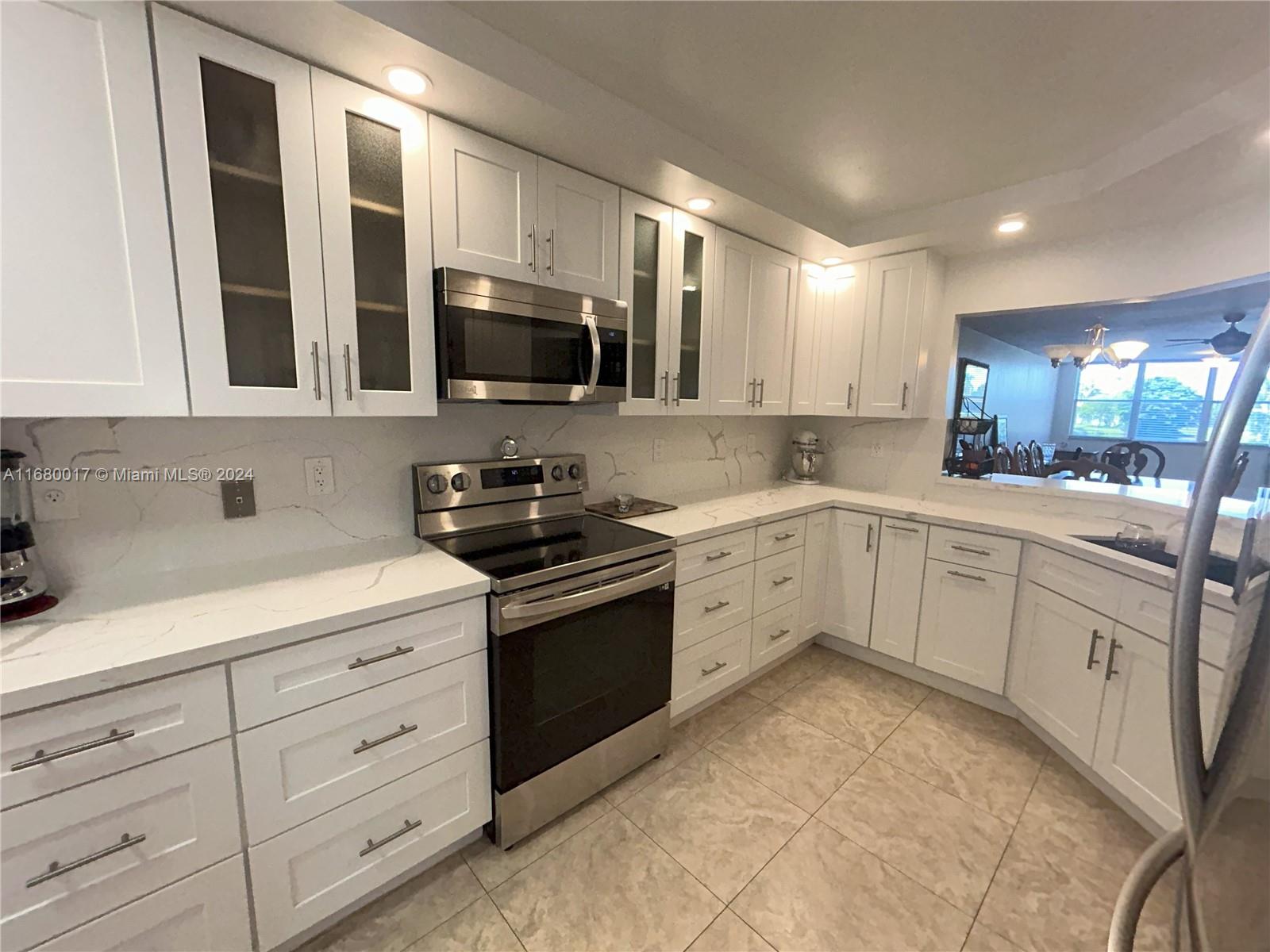 a kitchen with granite countertop a sink stainless steel appliances and cabinets