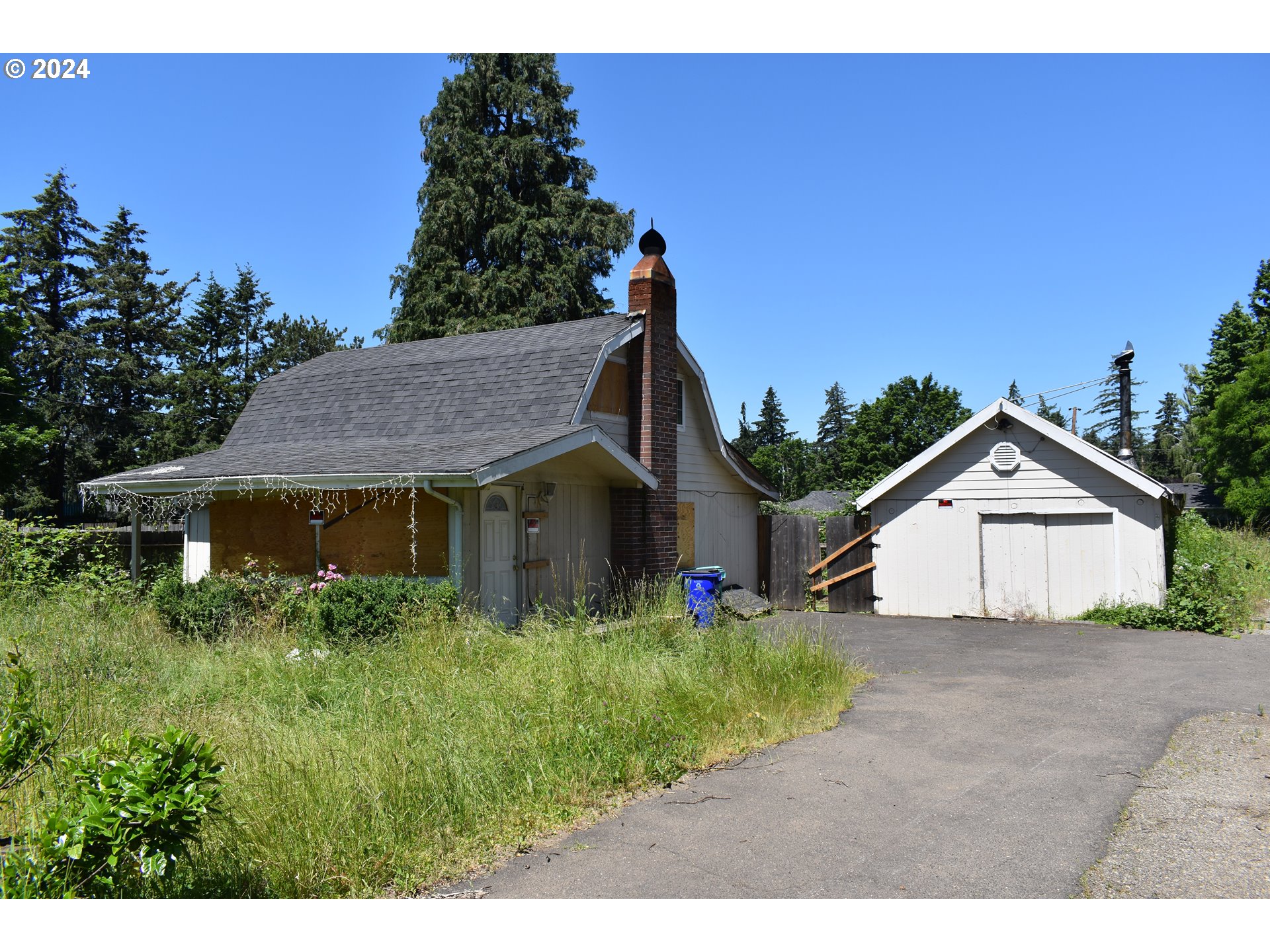 a view of a house with a yard and potted plants