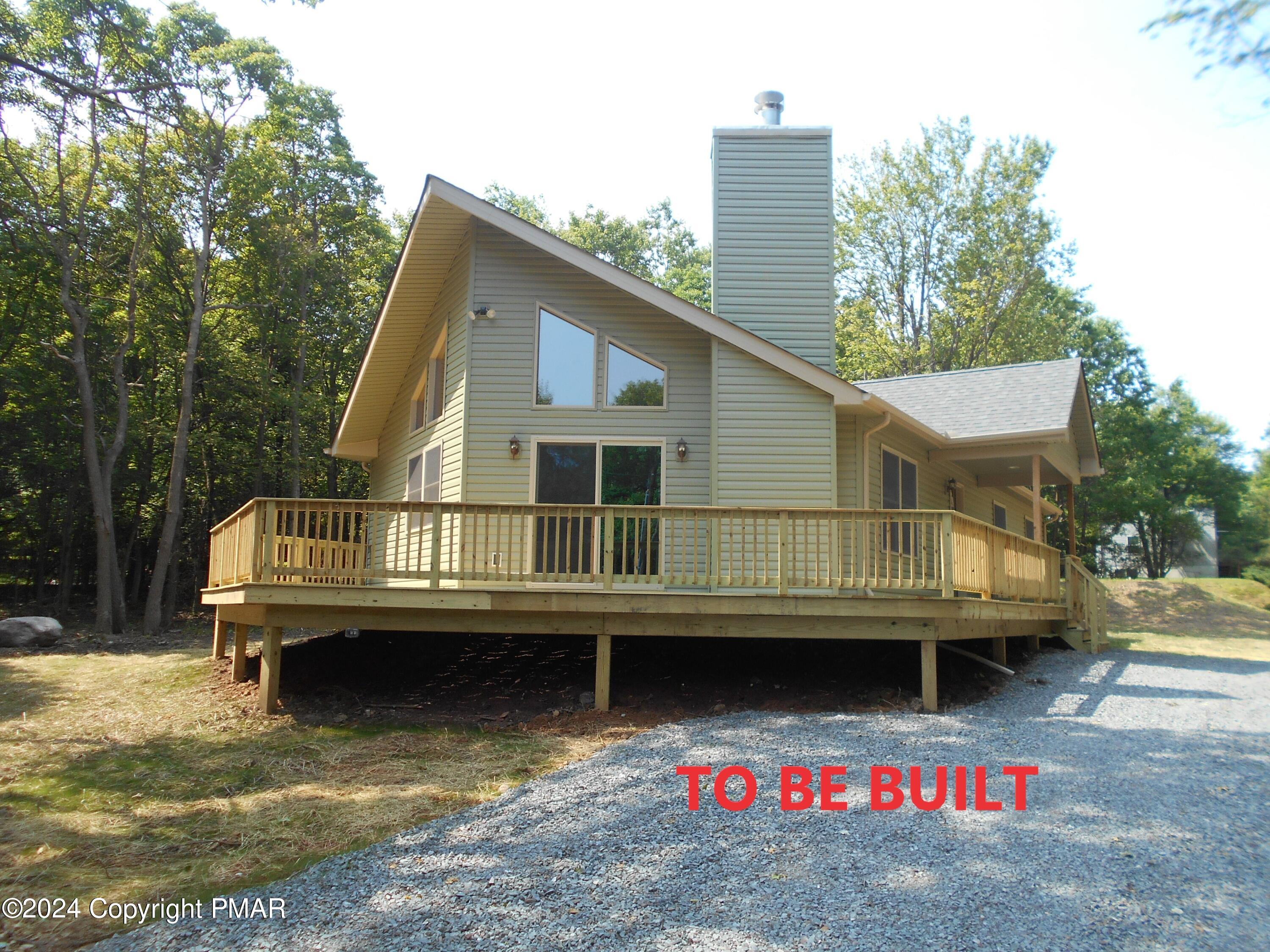 a view of a house with a wooden deck and a floor to ceiling window