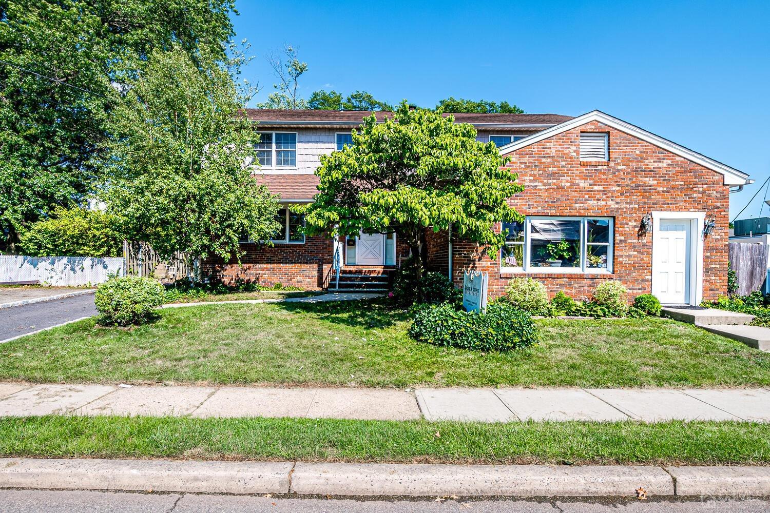 a front view of a house with a yard and potted plants