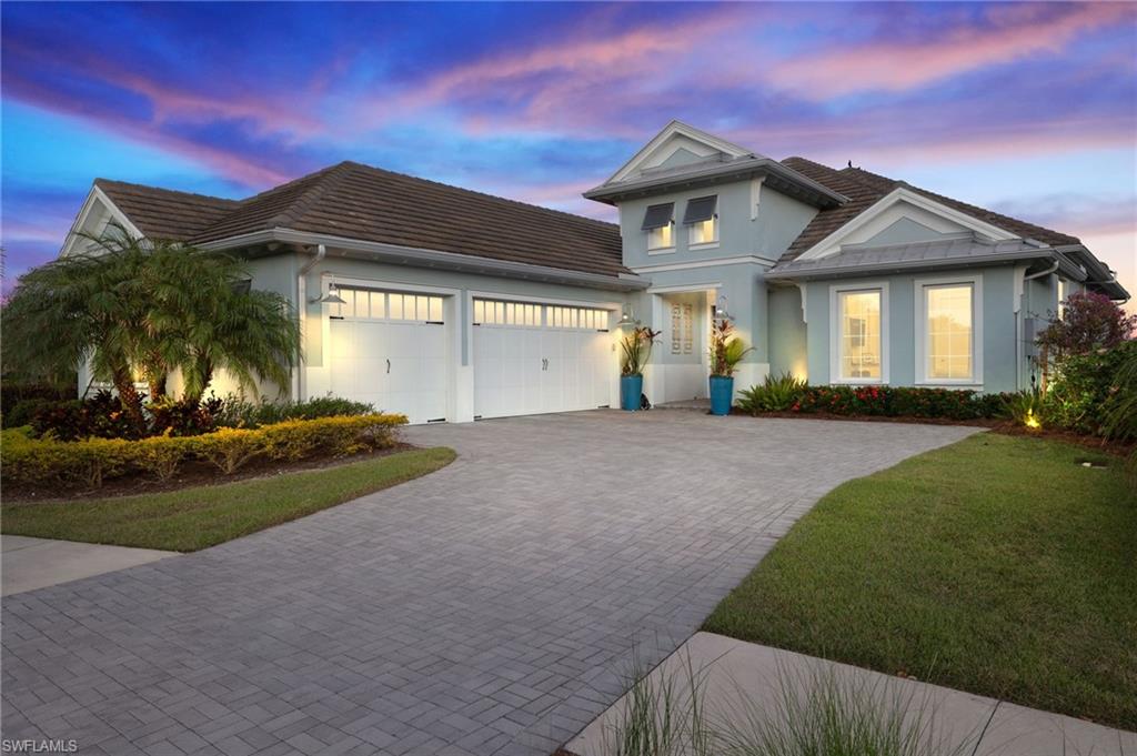 View of front facade featuring a yard and a garage