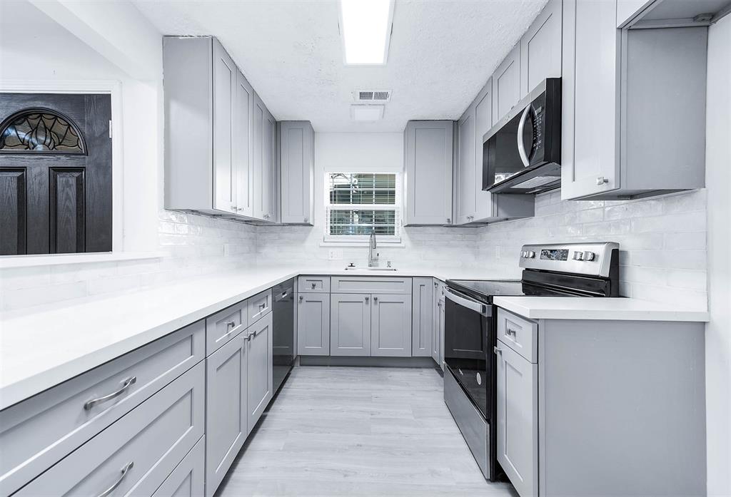 a kitchen with cabinets appliances a sink and a counter top space