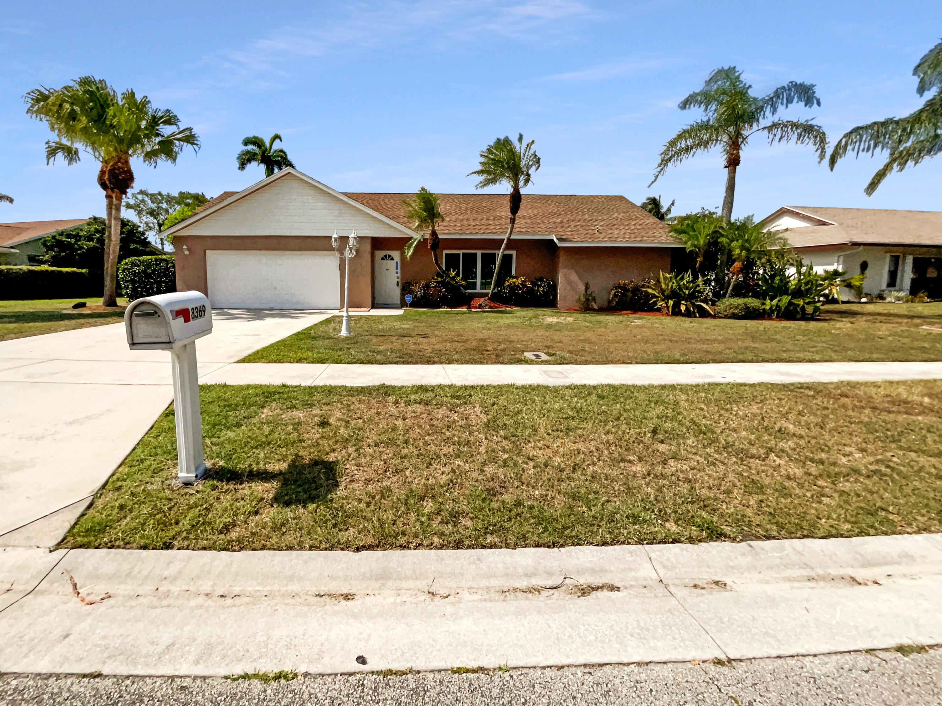 a front view of a house with a yard and mountain