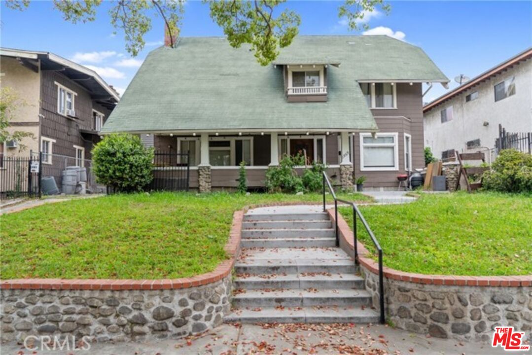 a front view of a house with a garden and plants